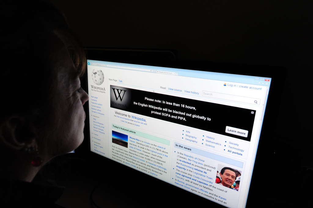 A journalist reads information on the on Free online knowledge site Wikipedia will shut down for 24 hours beginning at midnight eastern standard time in protest at draft anti-online piracy legislation before the US Congress, founder Jimmy Wales said Monday on Twitter. The website will join others, like Reddit and Boing Boing, in the protest.