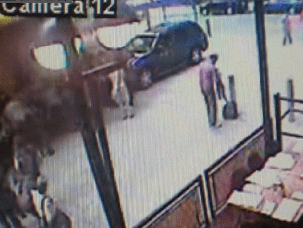 A frame made from a surveillance video released by the New York Police shows a man (right) removing a shirt, not far from where the Pathfinder containing explosive materials was parked.