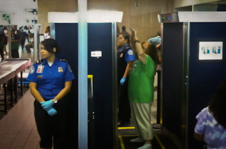 A passenger passes through a full body screener at LAX.