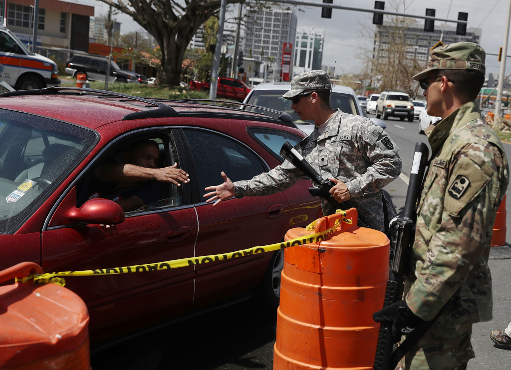 Puerto Rico Faces Extensive Damage After Hurricane Maria Puerto Rican National Guard Specialists David Sanchez and Ismael Segarra stand guard near a line of vehicles waiting for gas as they deal with the aftermath of Hurricane Maria in San Juan, Puerto Rico.