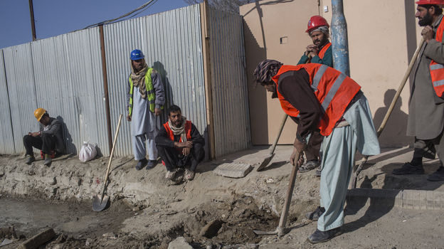 Afghan laborers work on a roads project last month in Kabul. A huge project to fix the city's roads and sewers is causing huge headaches.