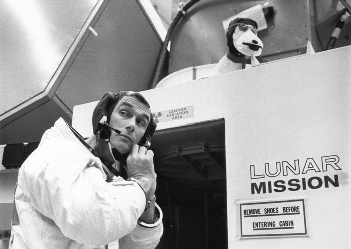 Gene Cernan prepares for his 1969 Apollo 10 flight, adjusting his headset outside a lunar module simulator.