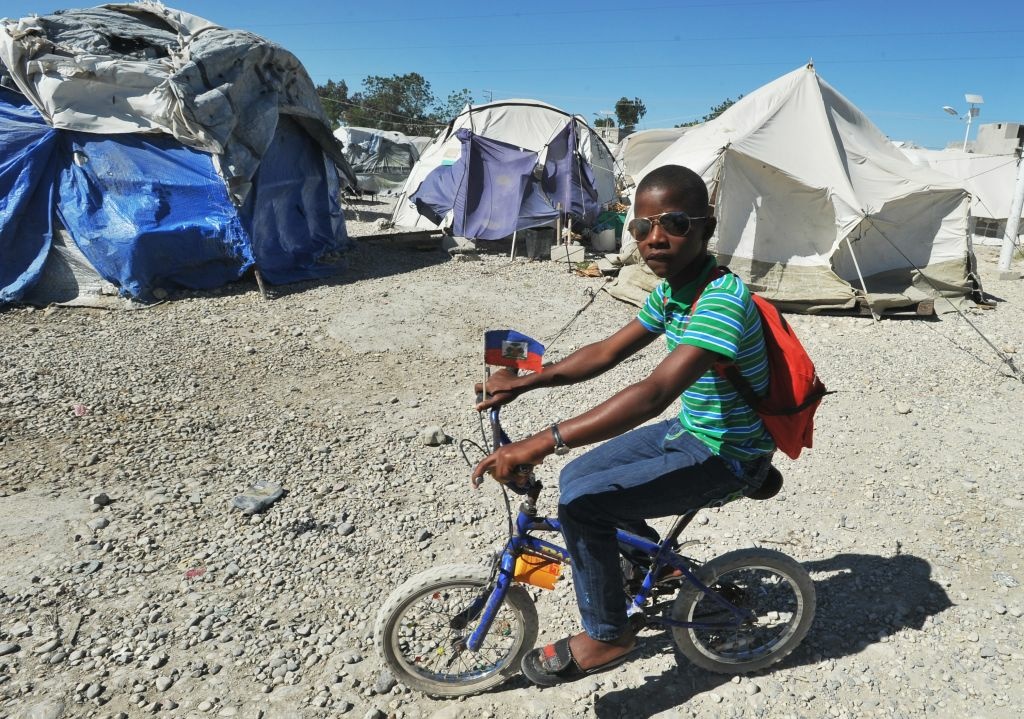 HAITI-QUAKE-POVERTY A view of a tent city is seen on January 8, 2013 in Marassa, a suburb of Port-au-Prince. Three years after the earthquake that devastated Haiti, 360,000 people are still living under tarps: among them, the inhabitants of the camps 'Marassa', located northeast of Port-au-Prince, who feel abandoned by everyone. About 750 families, or 5,000 people, coexist in these makeshift camps three 'Marassa' 9, 10 and 14, under the permanent threat of a large river that runs through the neighborhood.