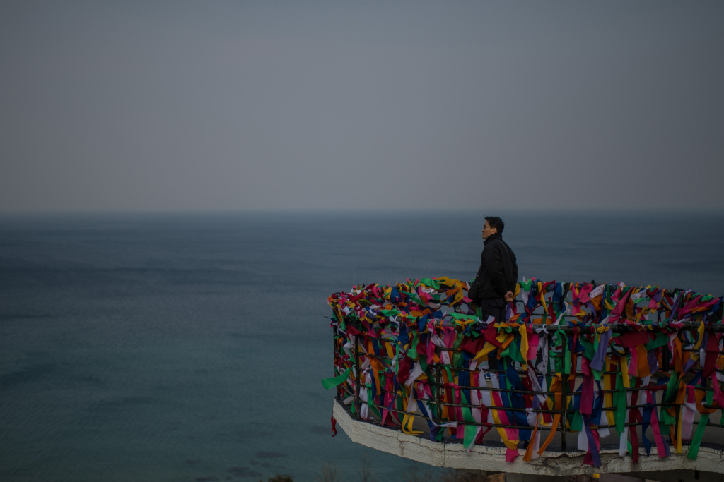 Tourists Visit Goseong Unification Observatory A man stands on a viewing platform covered with ribbons bearing goodwill messages as he looks towards North Korea from Goseong Unification Observatory on February 22, 2018 in Goseong-gun, South Korea.