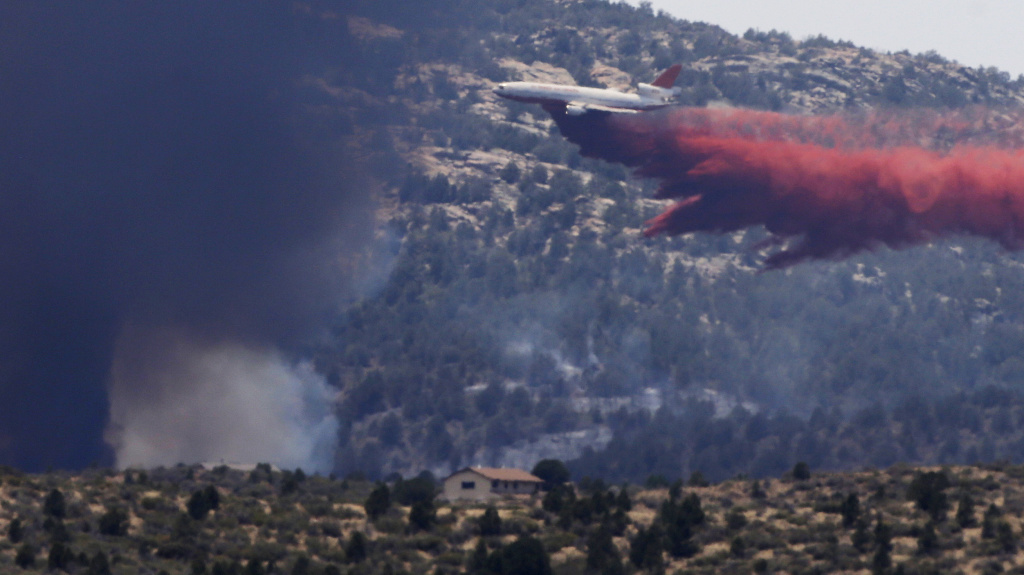 An aerial tanker drops fire retardant on a wildfire threatening homes near Yarnell, Ariz., on July 1. An elite crew of firefighters was overtaken by the out-of-control blaze on June 30, killing 19 members as they tried to protect themselves from the flame An aerial tanker drops fire retardant on a wildfire threatening homes near Yarnell, Ariz., on July 1. An elite crew of firefighters was overtaken by the out-of-control blaze on June 30, killing 19 members as they tried to protect themselves from the flames under fire-resistant shields.