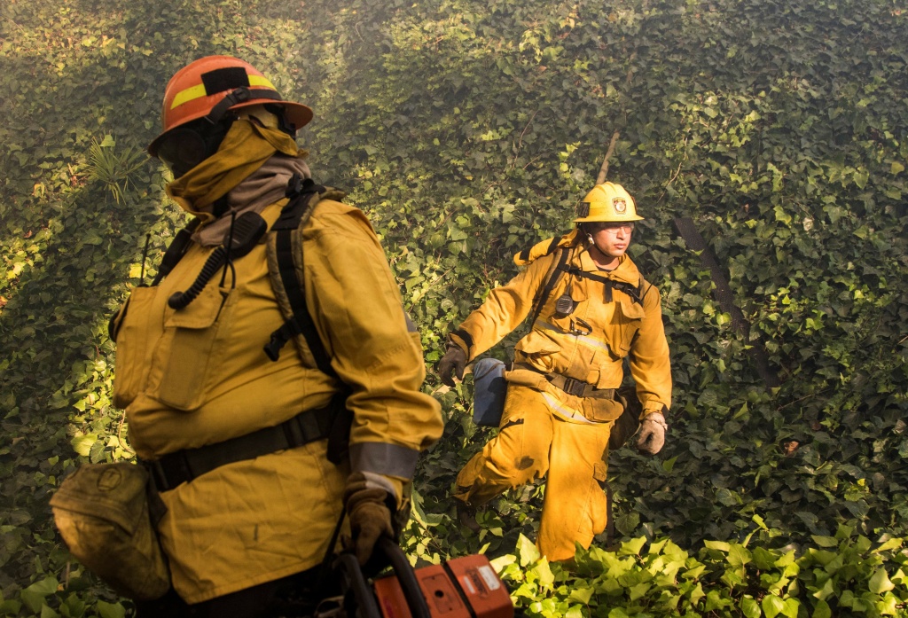 Skirball Fire Firefighters work to save burning houses along Linda Flora Drive during the Skirball Fire in Los Angeles, California, December 6, 2017. The Skirball Fiire ignited before 5 a.m. on Wednesday and quickly engulfed 50 acres.