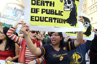 Demonstrators carry signs as they march to Oakland City Hall during a national day of action against school funding cuts and tuition increases on March 4, 2010 in Oakland. Students across the country walked out of classes and held demonstrations against massive tuition increases and funding cuts to college universities.
