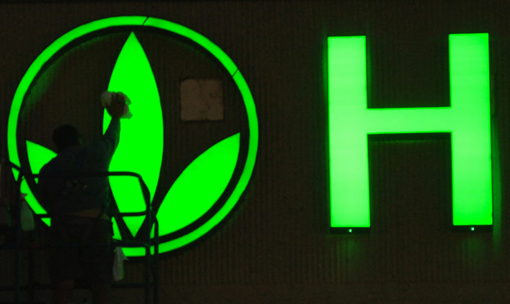 A worker cleans the logo on the Herbalife sign as finishing touches are put on the company's building in Torrance, Calif. Herbalife came out swinging Thursday, Jan. 10, 2013 against claims made by hedge fund manager William Ackman that the business amounts to a pyramid scheme.