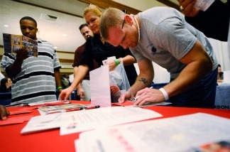 Job seeker and U.S. Navy veteran John Place (right) fills out an information form at the Los Angeles County Fire Department booth during 'Honor a Hero, Hire a Vet' job fair on Nov. 10, 2010 near LAX.