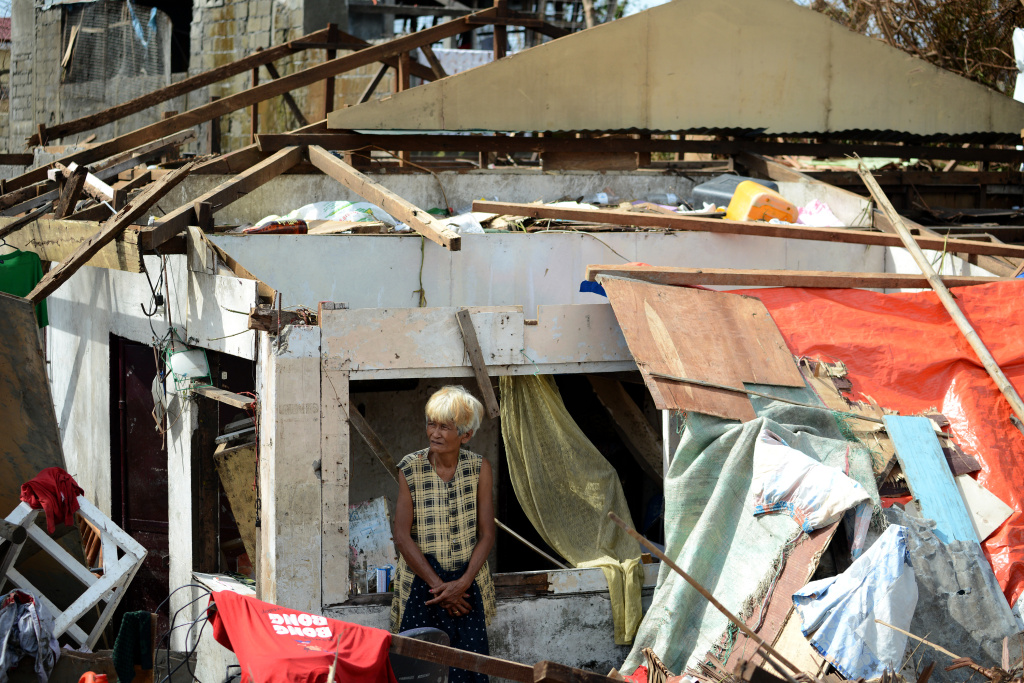 PHILIPPINES-WEATHER-TYPHOON A surivor stands among the debris of a house destroyed by Super Typhoon Haiyan in Tacloban in the eastern Philippine island of Leyte on November 11, 2013. The United States, Australia and the United Nations mobilised emergency aid to the Philippines as the scale of the devastation unleashed by Super Typhoon Haiyan emerged on November 11.
