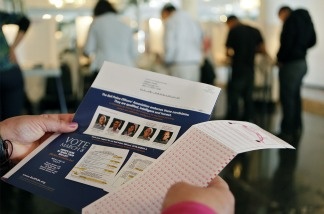 A voter holds a ballot and a flyer while waiting to vote in the special election in Bell on March 8, 2011.
