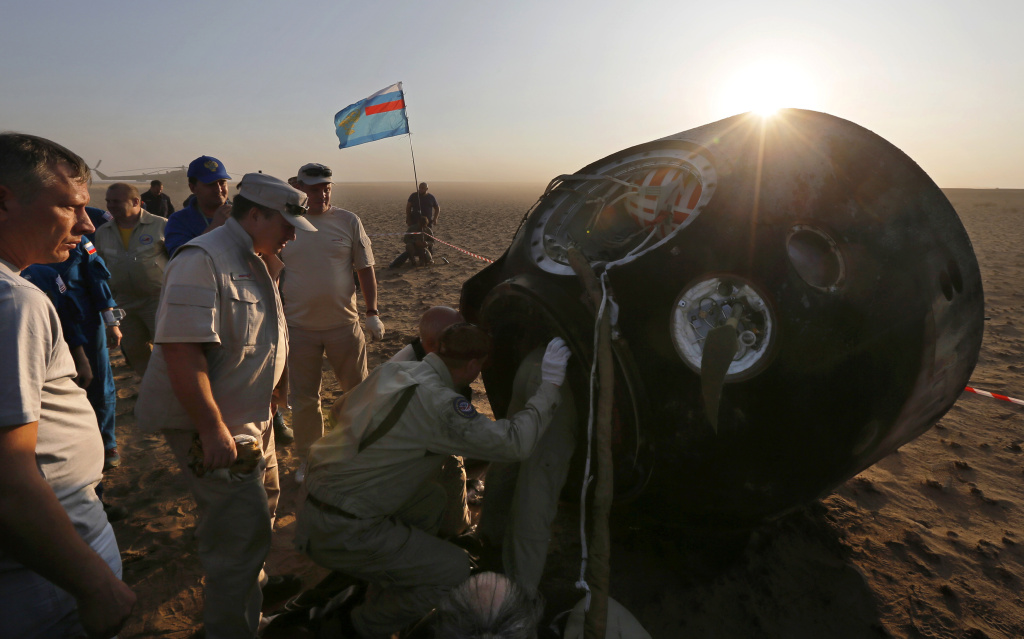 KAZAKHSTAN-RUSSIA-US-ISS-SPACE Ground personnel stand next to Russia's Soyuz MS-04 space capsule carrying the crew of Russian cosmonaut Fyodor Yurchikhin and US astronauts Peggy Annette Whitson and Jack Fischer after it landed in a remote area of Kazakhstan on September 3, 2017.