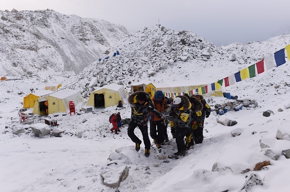 NEPAL-EVEREST-EARTHQUAKE-DISASTER An injured person is carried by rescue members to be airlifted by rescue helicopter at Everest Base Camp a day after an avalanche triggered by an earthquake devastated the camp.
