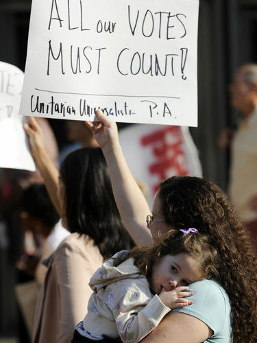 Emily Goldberg, with her daughter, Willa, 2, holds up a sign during the NAACP voter ID rally to protest against Pennsylvania's voter ID law on Sept. 13. Tuesday, a judge ordered that the law not be enforced in the Nov. 6 presidential election.