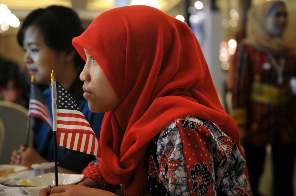INDONESIA-US-ELECTION Indonesian student of international relations Anisa Widya Lestari, (C), 20, holds a US flag as visitors watch US presidential elections.
