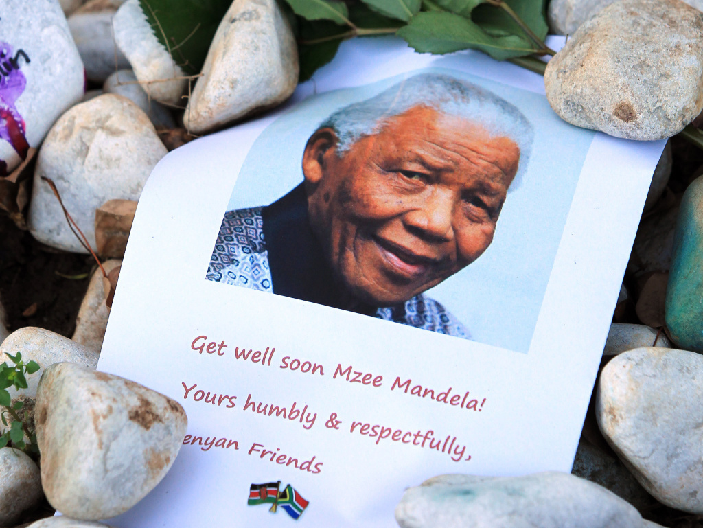 A print of Nelson Mandela and get well messages lay outside the home of the former President Mandela in Johannesburg, South Africa earlier this month.