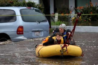 Jennifer Bowerman and her 7-year-old son Sabastian Bowerman are led across flood waters on a raft after being stranded in a hotel after a powerful rainstorm Dec. 22, 2010 in San Diego. Forty-seven guests were stranded at the Premiere Hotel after floodwaters rose and blocked them from getting to dry land.
