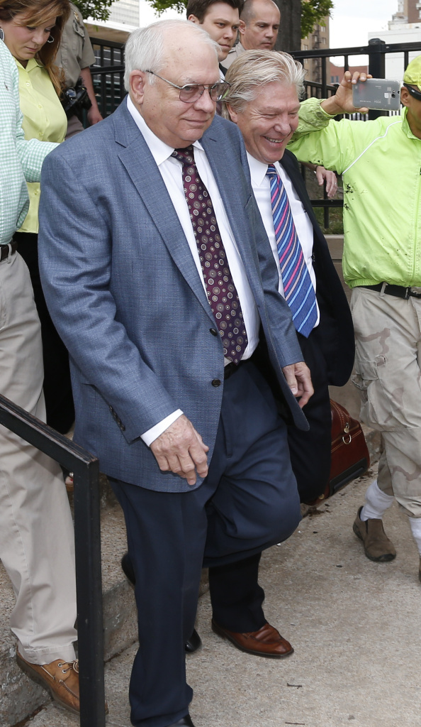 Tulsa County, Okla., reserve deputy Robert Bates leaves his arraignment with attorney Tuesday. Bates fatally shot a suspect who was pinned down by officers, raising alarms about volunteer police officers who wear badges and carry gun.