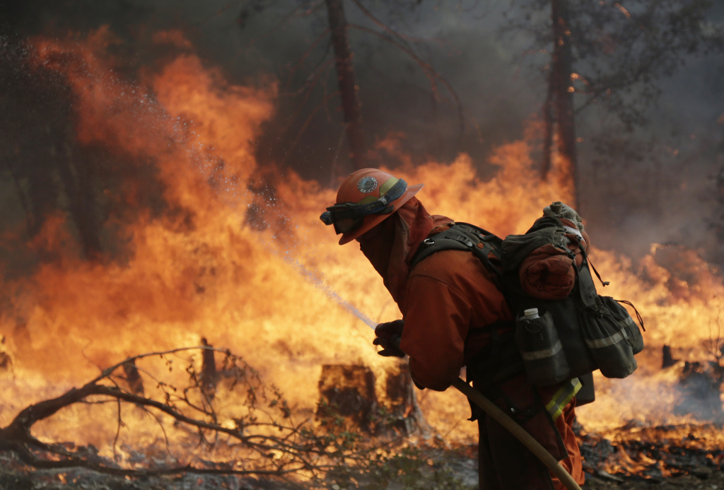 California Wildfires A firefighter with the Gabilan Camp crew hoses down hot spots during a controlled burn to fight the King Fire on Monday, Sept. 22, 2014, near Placerville, Calif. Crews scrambled Monday to extend control lines around a massive Northern California wildfire threatening thousands of homes as they braced for strong, erratic winds similar to when the blaze doubled in size a week ago. (AP Photo/Marcio Jose Sanchez)