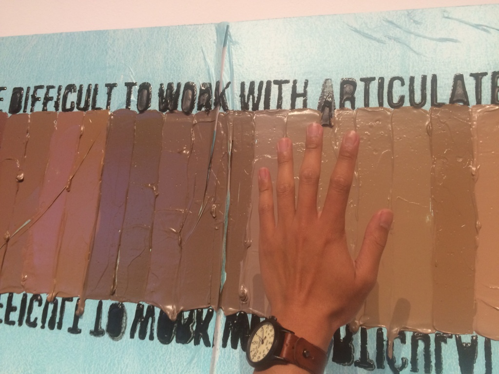 A piece by artist April Bey. KPCC's Leo Duran holds up his own hand to see what adjectives are associated with his skin tone. A piece by artist April Bey. KPCC's Leo Duran holds up his own hand to see what adjectives are associated with his skin tone.