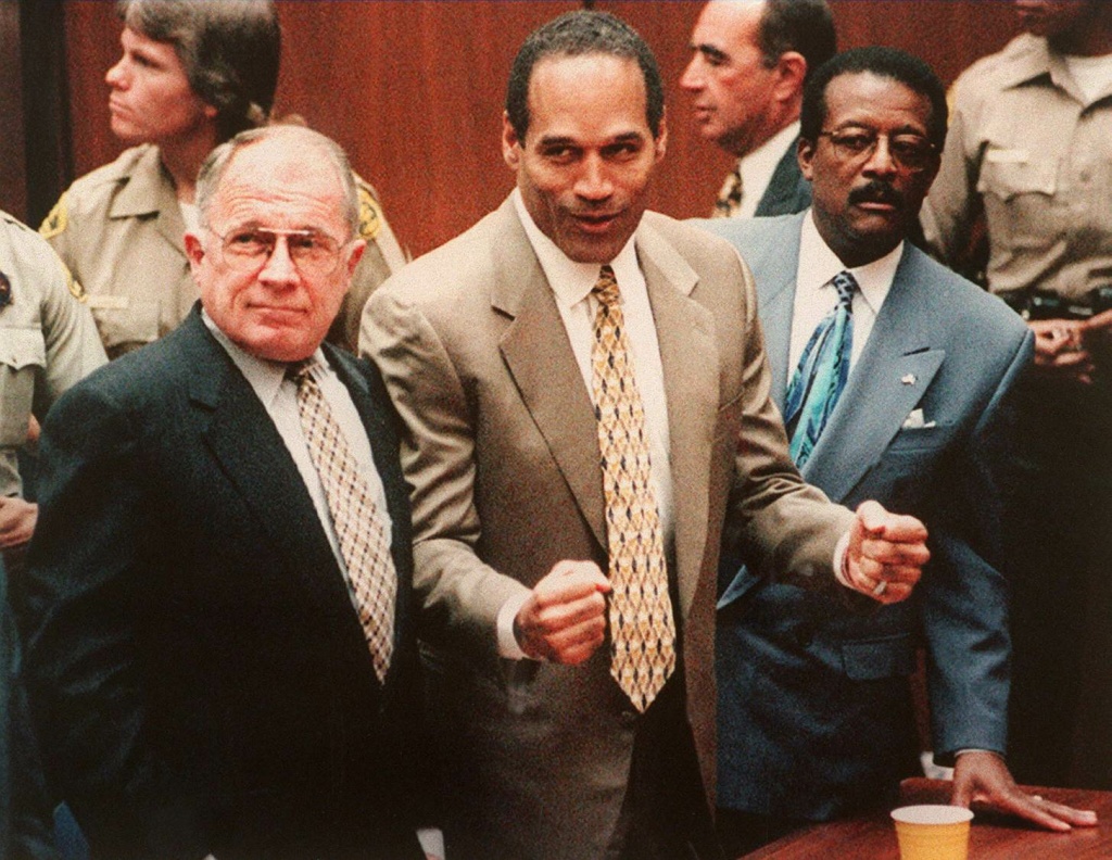OJ Trial Defendant O.J. Simpson (C) cheers while standing with his attorneys F. Lee Bailey (L) and Johnnie Cochan Jr (R), after hearing the not guilty verdict in his criminal murder trial, Los Angeles, California on October 3, 1995.