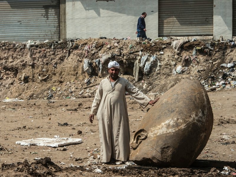 An Egyptian worker stands next to the head of a statue at the site of a new discovery by a team of German-Egyptian archaeologists in Cairo's Matariya District. An Egyptian worker stands next to the head of a statue at the site of a new discovery by a team of German-Egyptian archaeologists in Cairo's Matariya District.