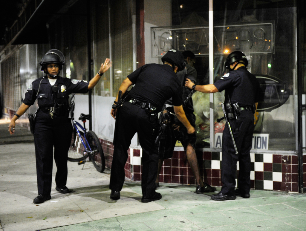 Los Angeles Police Department officers in riot gear detain a man after disturbances in the streets around Leimert Park. Los Angeles Police Department officers in riot gear detain a man after disturbances in the streets around Leimert Park.