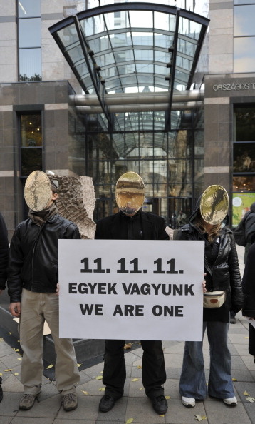 Hungarian and foreign activists and symp Hungarian and foreign activists and sympathizers of the 'True Democracy Now' group stand with a banner reading '11.11.11. We are one' in front of a bank in downtown Budapest on November 11, 2011