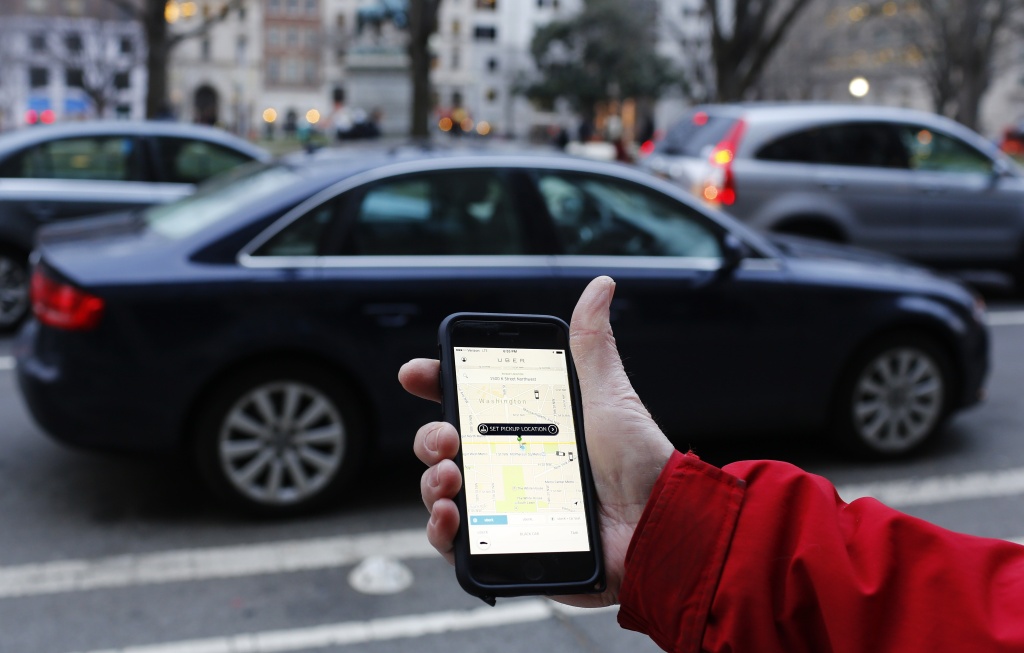 US-ECONOMY-TRANSPORT-UBER An UBER application is shown as cars drive by in Washington, DC on March 25, 2015.