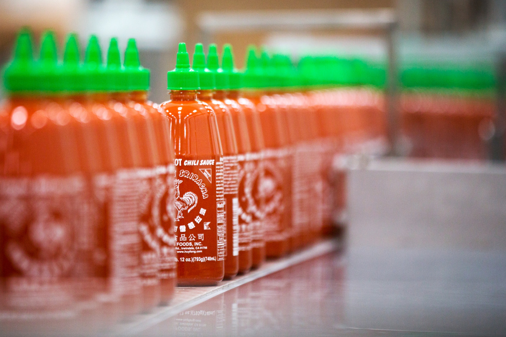 Sriracha Factory - 1 Twenty-eight-ounce bottles of Sriracha hot sauce are transported by conveyor belt to be packed and shipped inside Huy Fong Foods Inc. in Irwindale on Tuesday, Aug. 19.