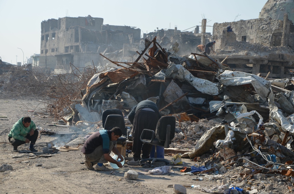 IRAQ-CONFLICT-MOSUL-RECONSTRUCTION A picture taken on December 16, 2017 shows Iraqi volunteers salvaging and cleaning up the debris and destruction in the Bab al-Saray area in the old city of the northern Iraqi city of Mosul.
