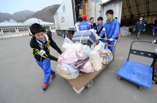 Volunteers push a trolley filled with blankets destined for displaced people in the city of Kamaishi in Iwate prefecture.