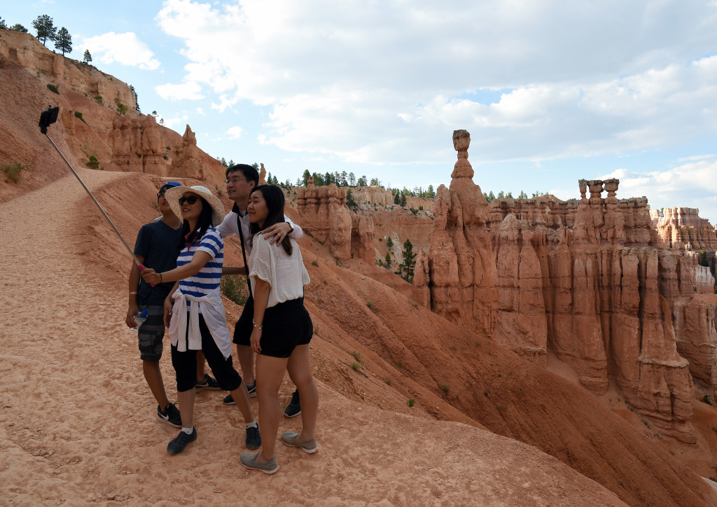 Views Of Bryce Canyon National Park Visitors take a selfie on August 12, 2016 in front of hoodoos named Thor's Hammer and the Three Sisters along the Navajo Loop Trail in Bryce Canyon National Park, Utah.