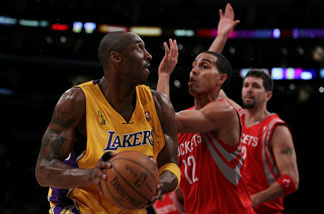 Kobe Bryant #24 of the Los Angeles Lakers looks to move the ball against Kevin Martin #12 of the Houston Rockets during their opening night game at Staples Center on October 26, 2010 in Los Angeles.