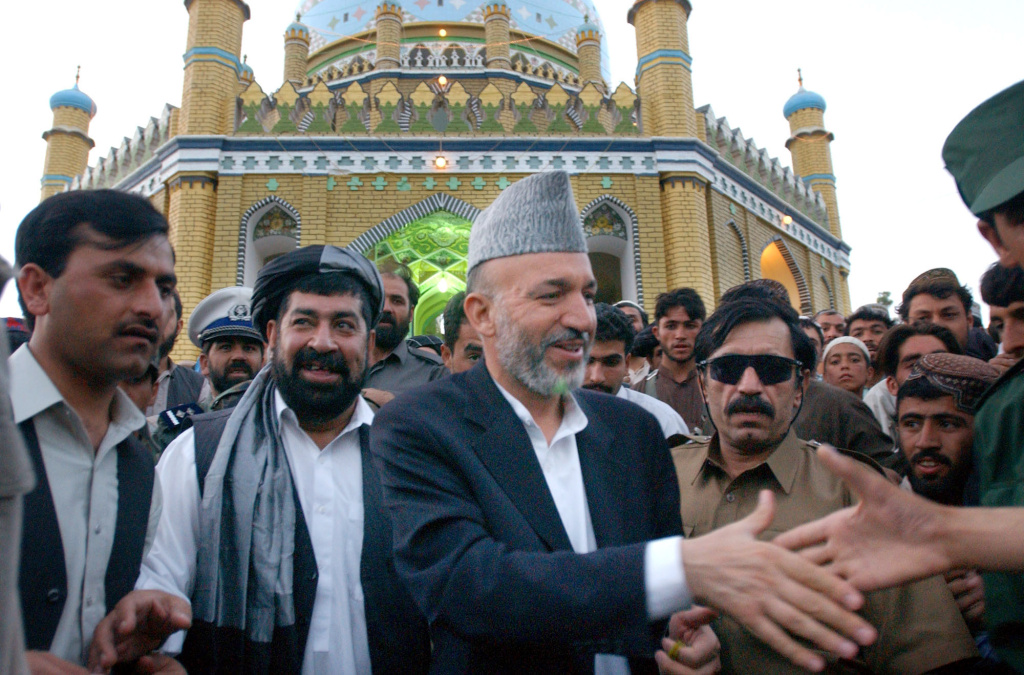 Haji Gulalai Afghan President Hamid Karzai, center, shakes hands with a supporter as he leaves the Mirwaise Nikah shrine (the tomb of a Pashtun tribal leader) in Kandahar, Afghanistan on Friday, Aug. 2, 2002. On the President's right is Gul Agha, governor of Kandahar, and on the president's left is the Afghan Chief of Intelligence, Haji Gulalai.