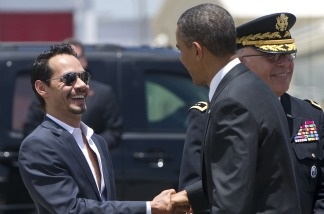 US President Barack Obama (R) greets singer Marc Anthony after disembarking from Air Force One upon arrival at Luis Munoz Marin International Airport in San Juan, Puerto Rico, June 14, 2011.