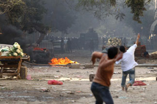 Mercer 14312 Egyptian demonstrators confront riot police during demonstrations in Cairo on January 28, 2011, demanding the ouster of President Hosni Mubarak.