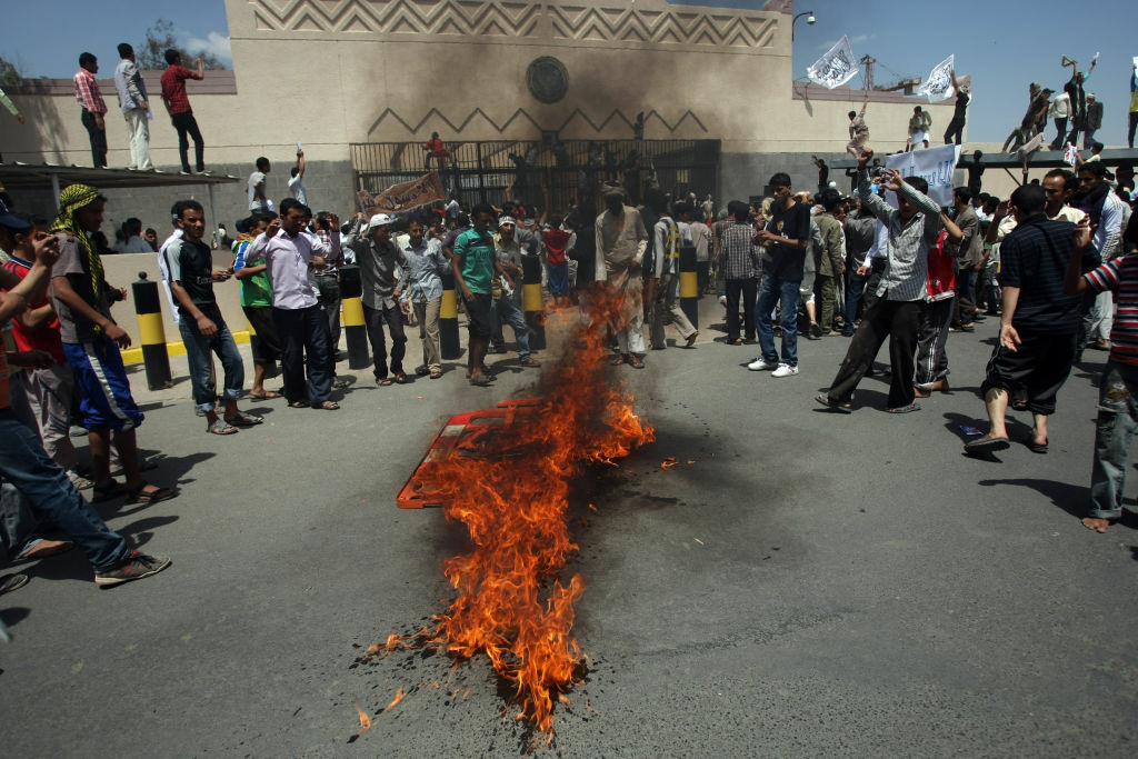 YEMEN-UNREST-US-FILM-PROTEST Yemeni protesters gather around fire during a demonstration outside the US embassy in Sanaa over a film mocking Islam on September 13, 2012. Yemeni forces managed to drive out angry protesters who stormed the embassy in the Yemeni capital with police firing warning shots to disperse thousands of people as they approached the main gate of the mission.