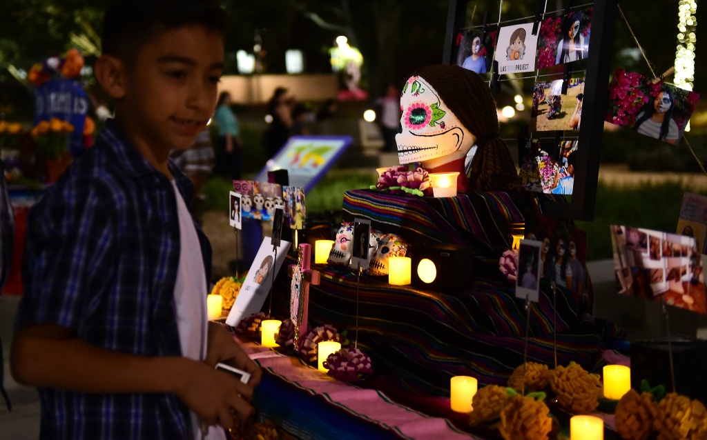 US-MEXICO-TRADITION-ALTARS A boy views objects displayed on altars during a traditional Mexican celebration of 'Noche de Ofrenda' (Night of the Altars) in downtown Los Angeles, California on October 25, 2014, a week before the 'Day of the Dead' celebration on November 1.