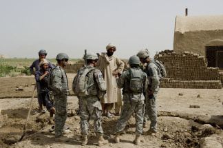 US soldiers from 1st Platoon Bravo Troop of 1st Squadron, 71st Cavalry talk with villagers during a patrol in Dand district of Kandahar Province in Afghanistan on July 24, 2010.