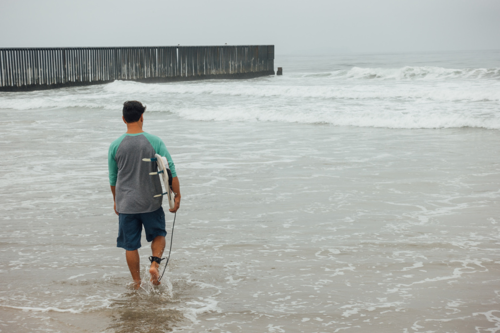 Surf Border Diego Palacios L.A. artist Diego Palacios heads out to surf at the border between the U.S. and Mexico on August 12th, 2017. The Beach at Border Field State Park in San Diego, CA is located in the farthest Southwest corner of the United States, separated from Playas de Tijuana by an 18-foot high fence.