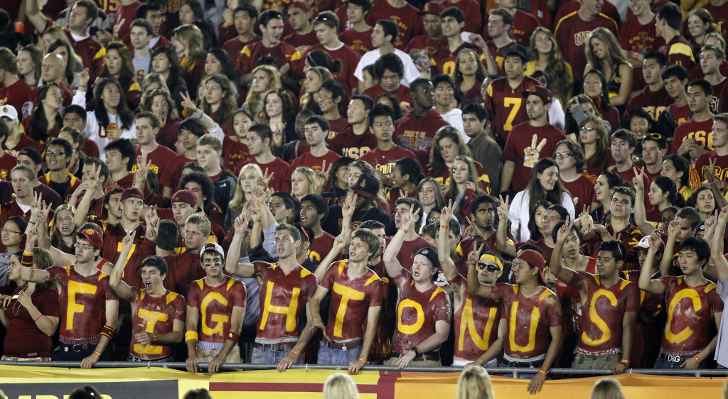Virginia USC Football Fans cheer with their chests painted in the student section of the Los Angeles Memorial Coliseum.