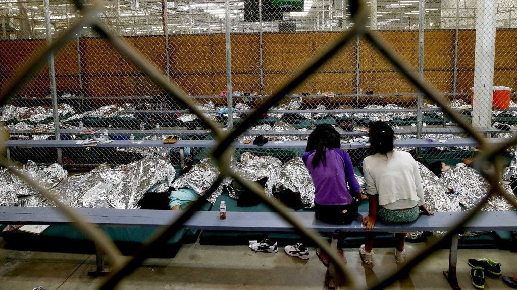 Two young girls watch a World Cup soccer match on a television at the U.S. Customs and Border Protection Nogales Placement Center in Nogales, Ariz. Two young girls watch a World Cup soccer match on a television at the U.S. Customs and Border Protection Nogales Placement Center in Nogales, Ariz.