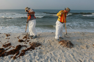 Workers on June 7, 2010, clean up oil residue from Pensacola Beach in Florida.