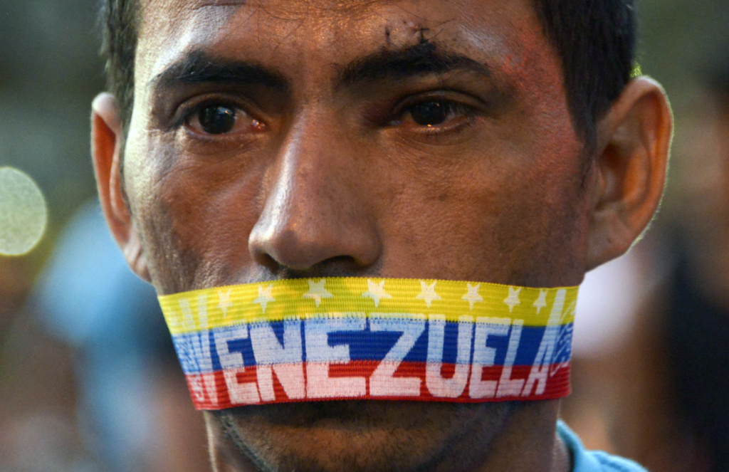 VENEZUELA-POLITICS-OPPOSITION-PROTEST A man attends a protest against the government of Venezuelan President Nicolas Maduro in Caracas on February 23, 2014. A total of 25 people were injured overnight during clashed between opposition groups and police in eastern Caracas. On Saturday the lasgest opposition rally had taken place after almost three weeks of students protests, which left ten people killed.