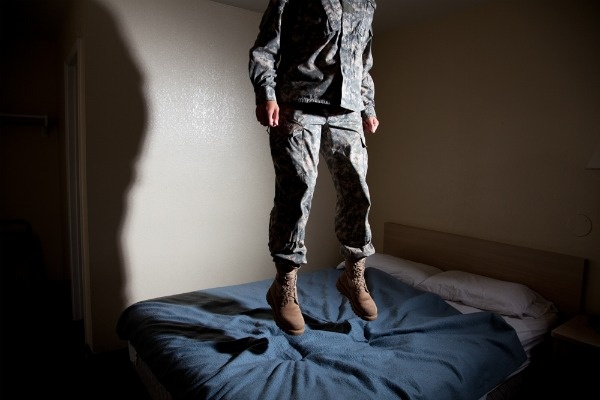 Grace is photographed jumping on a bed for Jeff Sheng's "Don't Ask, Don't Tell" exhibit.