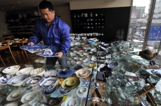 The owner of a ceramic shop checks his damaged wares following the massive 8.9-magnitude earthquake in Tokyo on March 11, 2011. The huge earthquake shook Japan, unleashing a powerful tsunami that sent ships crashing into the shore and carried cars through the streets of coastal towns.