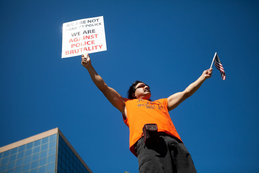 Anaheim Residents Protest Police Shootings Over Weekend A protester marches through the streets of Anaheim to show outrage for the shooting death of Manuel Angel Diaz, 25, at Anaheim City Hall on July 24, 2012 in Anaheim, California. Diaz was fatally shot July 21 by an Anaheim police officer and has sparked days of protests by the angered community.