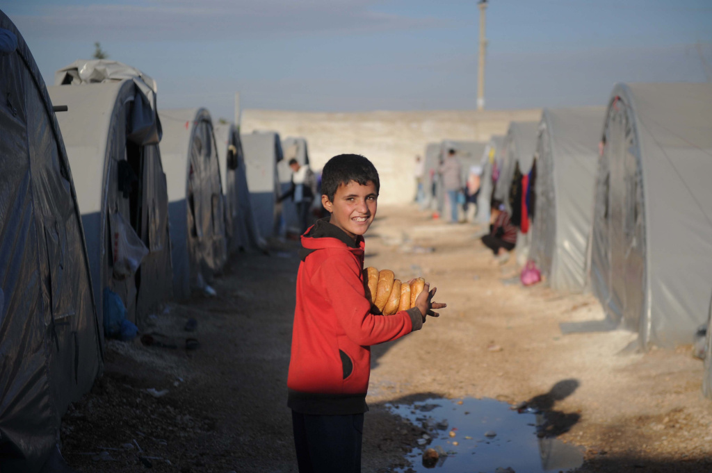 Syrian Kurds Battle IS To Retain Control Of Kobani A Kurdish refugee from the Syrian town of Kobani carries loaves of breads to his family tent for breakfast in a camp in the town of Suruc on October 25, 2014.
