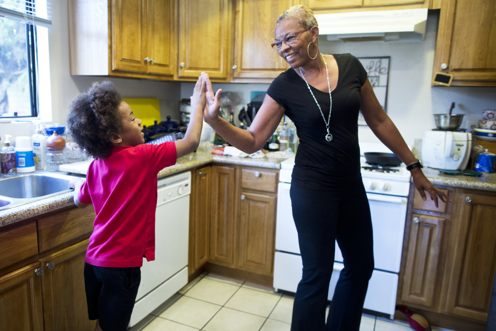 Tonia McMillian, a home-based child care provider, high-fives 6-year-old Skylar on Feb. 12 in her Bellflower home. Providers like McMillian will finally see a raise to the reimbursement rate they receive for low-income children. It has been stuck at 2005 market rates. This budget gives a slight bump to a rate with the effective market equivalent from 2007. 